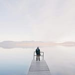 pexels-photo-571169-571169 A solitary traveler stands on a dock enjoying the serene water view
