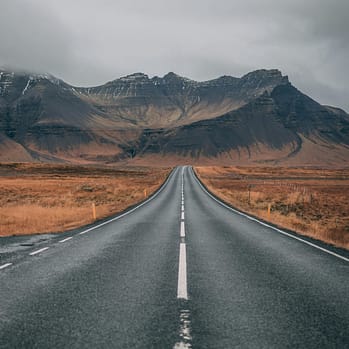 pexels-photo-1955134-1955134 A scenic empty road stretches into snow-capped mountains under cloudy skies, offering a sense of adventure and tranquility.